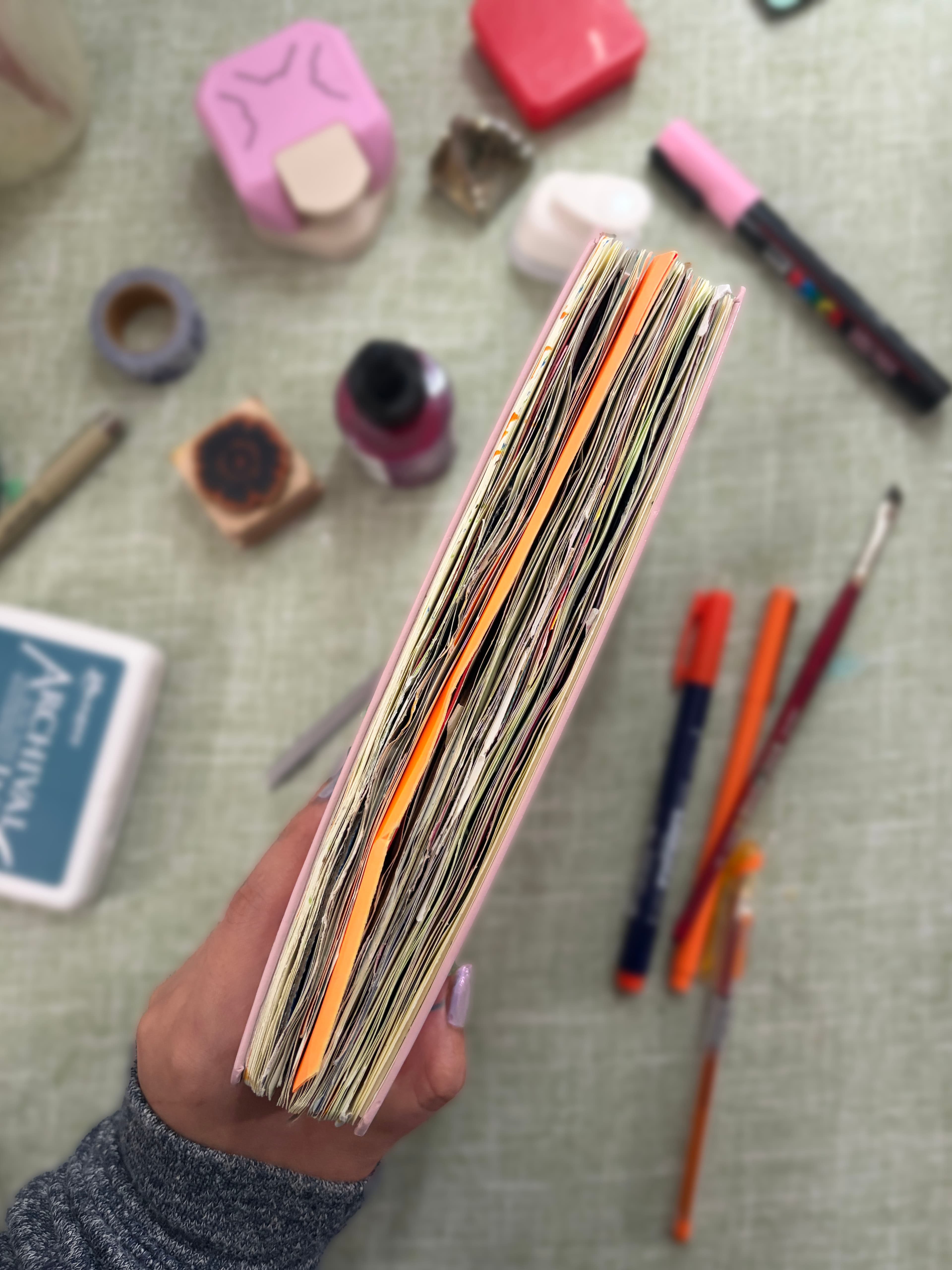 Open collage journal surrounded by cut paper and creative materials